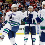 Vancouver Canucks left wing Chris Higgins, left, celebrates his first-period goal with defenceman Jason Garrison (5) during NHL game against the Detroit Red Wings on Sunday, Feb. 24, 2013, in Detroit.
Photograph by: Duane Burleson , AP