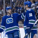 Henrik Sedin celebrates a goal with Jannik Hansen.  (Photo by Rich Lam/Getty Images)